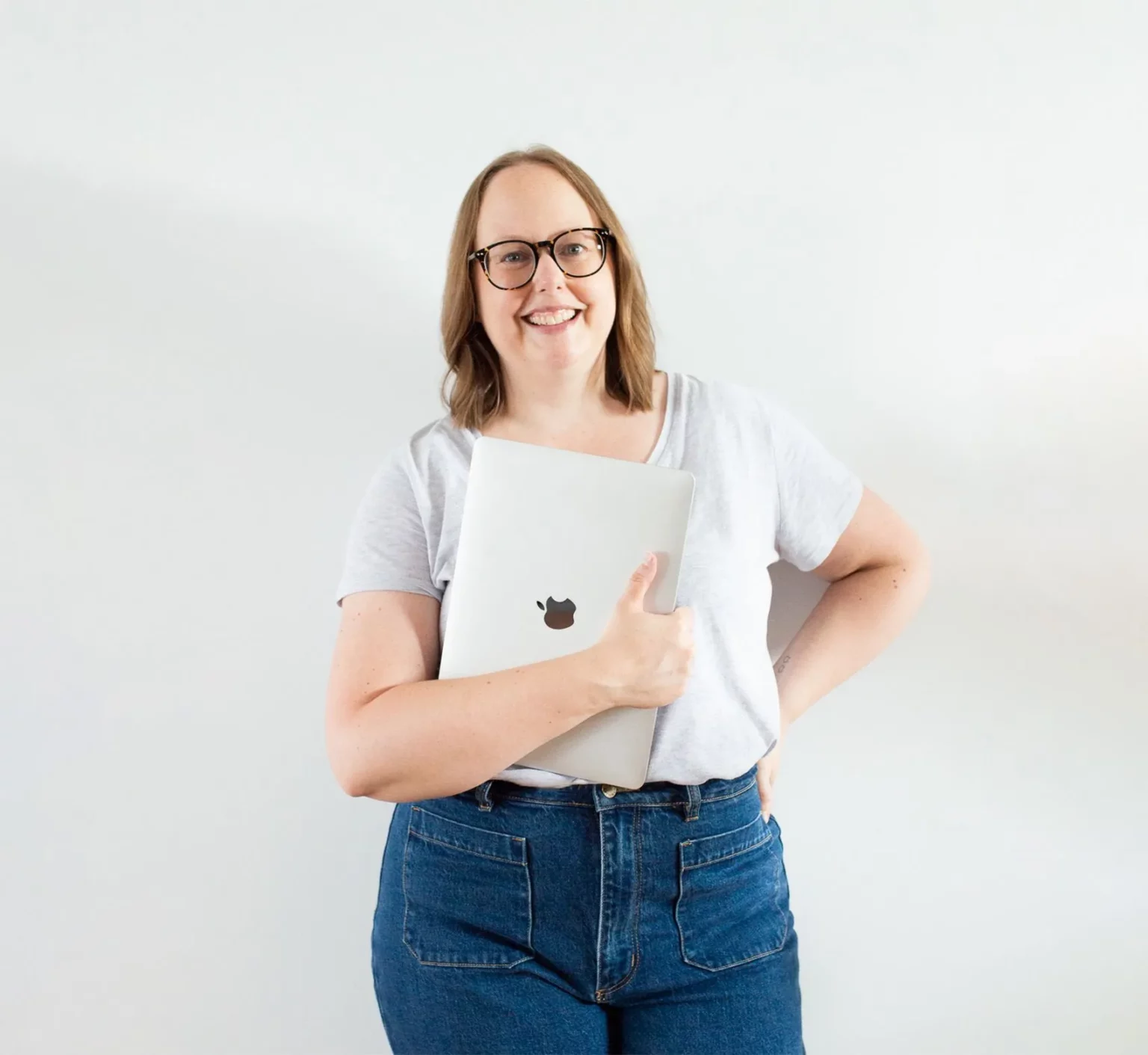 Nina Mills website designer, copywriter and SEO from Butter Digital holding a laptop.