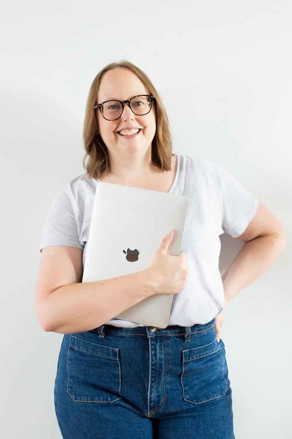 Nina Mills website designer, copywriter and SEO from Butter Digital holding a laptop.